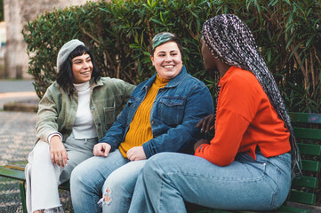 Diverse female friends sharing authentic conversation outdoors - Natural friendship moment
