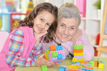 Cute girl and grandmother playing