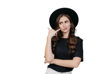 Brunette hipster girl in hat , black t-shirt makes call gesture by hand looks aside at copy space against transparent background. Caucasian fashion model shows sign call me. Mockup, promo, sale.