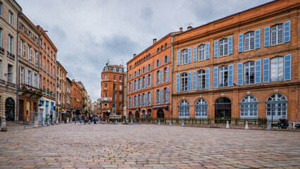 Fototapeta na wymiar Fountain, obelisk and brick facades of Saint Etienne square in Toulouse old town in the south of France (Haute Garonne)