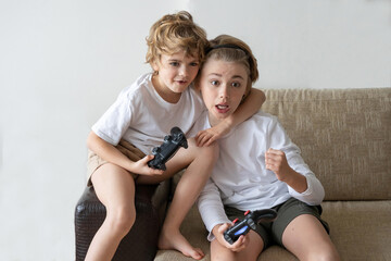 Addicted children playing video game playstation joystick controller at home. Harm of online gadget...
