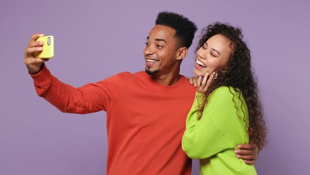 Young couple two friends family man woman of African American ethnicity wear casual clothes together do selfie shot photo on mobile phone send air kiss isolated on pastel plain light purple background