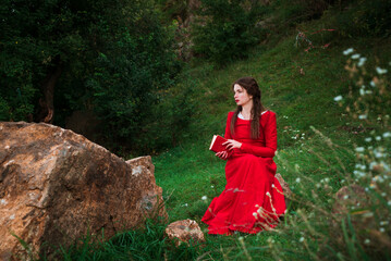 Vintage portrait of a beautiful noble lady in a red dress with a book in the garden 2