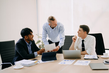 Office colleagues have a casual discussion. During a meeting in conference room, a group of business teem sit in the conference room new startup project..