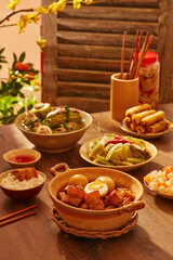 Vietnamese traditional meal with pork stuffed bitter melon soup, spring roll and caramelized pork and eggs