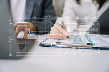 Businessman team hand Project manager working and update tasks and Gantt chart scheduling virtual diagram.with tablet and laptop in office.