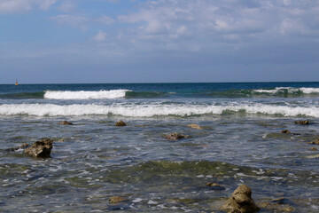 Sea coast. Seascape. Ocean is shaking. Small waves roll on the sandy beach.