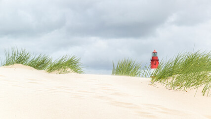 tiefe Ansicht eines Leuchtturms am hellen Sandstrand an der Nordsee
