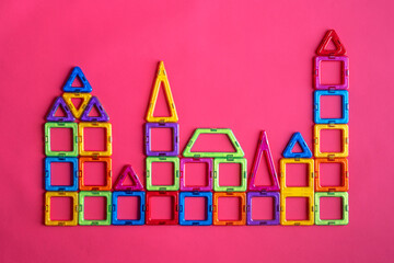 Model of the city from a magnetic constructor on a pink background.