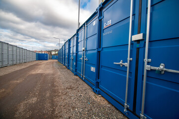 Cargo containers in the storage area. Blue and gray containers in a row.
