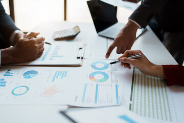 Team business adviser meeting to analyze and discuss the situation on the financial report n the meeting room with using calculator, documents, computer laptop in work.