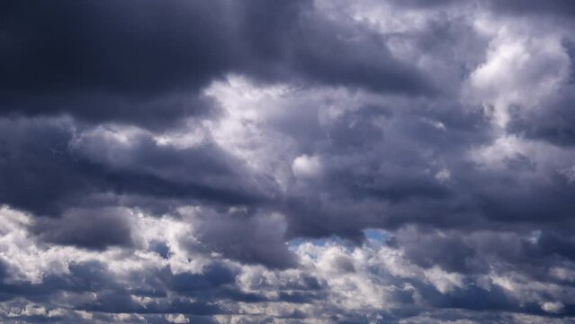 Timelapse of storm clouds moving in the sky. Cloud space background with dark and light cumulus clouds changing shape, time lapse. Change of weather. Nature, winter sky clouds, copy space, atmosphere