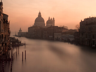 Obraz na płótnie Canvas Grand Canal, Venice, Italy. Very early at dawn, fog and mist, no people. Basilica di Santa Maria della Salute in distance.