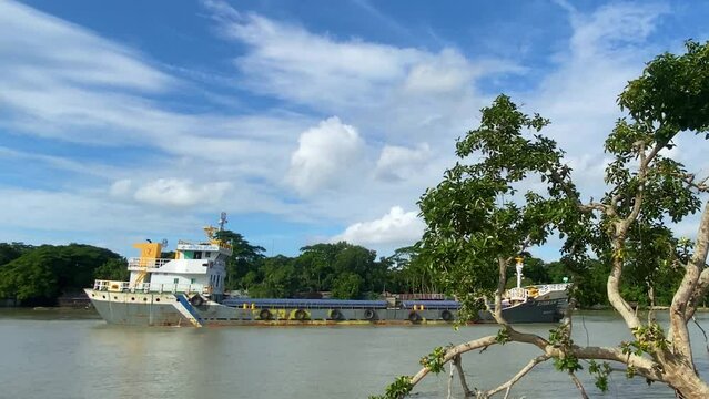 Tracking shot of a small cargo barge sailing through river in Sylhet