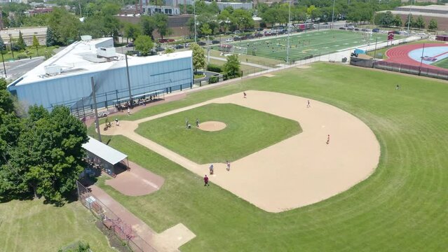 Aerial View of People Playing Baseball on Diamond in Summer. Slow Push In