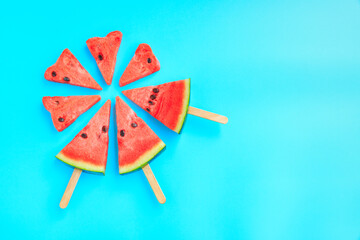 Watermelon fruit sliced with wood ice cream stick on blue pastel background, Watermelon ice cream, watermelon popsicle, Summer concept