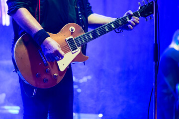Male singer and guitarist on stage lights