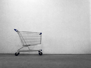 Empty shopping cart on cement texture background
