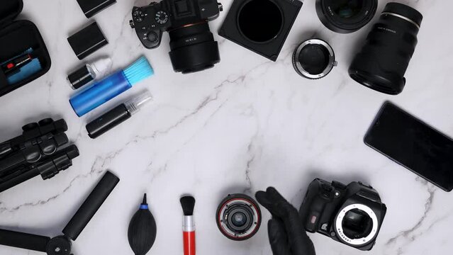 Professional cleans her DSLR camera lens with an air blower and soft brush. Cleaning kit and photo set around a copy space