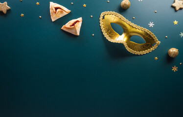 Happy Purim carnival decoration concept made from golden mask star and glitter on dark background....