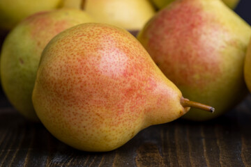 A yellow ripe pear with a red side on the table