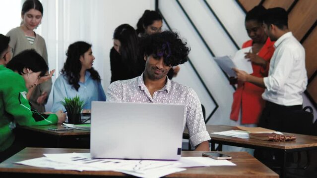 Tired stressful young man working on a laptop, Browsing internet. Hard studying, busy student, sad. Handsome indian businessman working on laptop computer at office. Students at classroom chat study