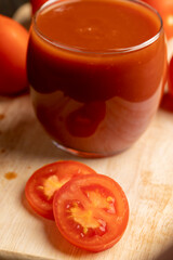 Fresh red tomato juice poured into a glass