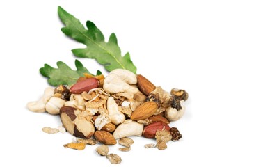 Dried fruits with nuts mixed with fresh green leaves.