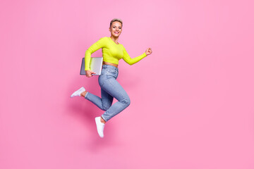 Full length profile photo of overjoyed excited person jump hurry rush hold laptop isolated on pink color background