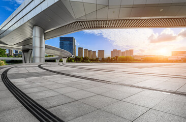 Empty square floor and pedestrian bridge with city skyline at sunset in Ningbo, Zhejiang Province, China.
