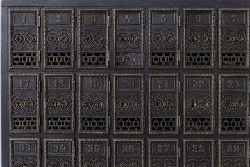 Lot mail cells in the post office. Antique letter box. Old retro copper mailboxes with numbers.