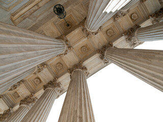 Upward view of the US Supreme Court columns with cut out sky.