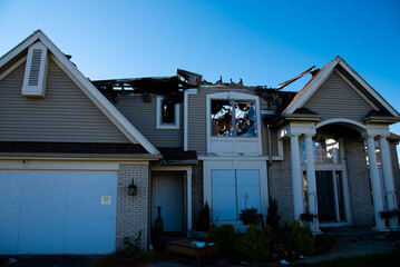 Front door garage of two-story single-family home with shingle roof ruined by fire in Rochester,...