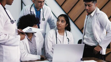 Medical indian students discussing  in a group. Science students doing  experimental project in the laboratory at university or library. High-skilled team of five young mixed race confident students - Powered by Adobe
