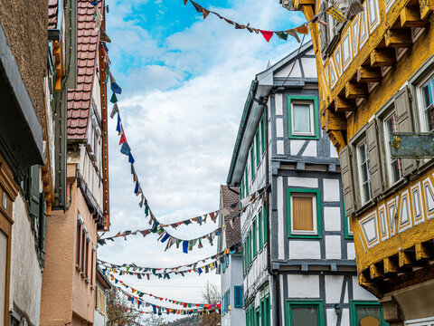 Fachwerkh&auml;user mit bunter Narrenw&auml;sche / Stofft&uuml;chern an W&auml;scheleinen h&auml;ngend als Tradition zur Fasnet in der Fu&szlig;g&auml;ngerzone der schw&auml;bischen Stadt Herrenberg