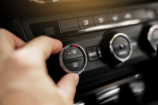 Closeup of hand adjusting the conditioner in a modern car. Dashboard with air flow, climate control and temperature button temperature button inside transport. Car HVAC System. Detail interior of car