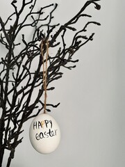 The Easter egg is hanging on a branch.