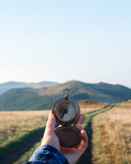 Man with compass in hand on mountains road. Travel concept. Landscape photography © Ivan Kmit