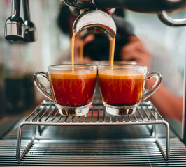 Professional espresso machine while preparing two espressos shot in a coffee shop. Close-up of espresso pouring from the coffee machine