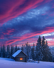 Fantastic landscape glowing by sunlight. Dramatic wintry scene with snowy house. Carpathians, Ukraine, Europe.
