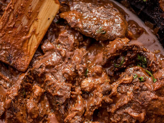 Meat roast. Beef with red wine sauce, top view, copy space. Roasted beef meat. Braised beef portion meat. Slow cooked meat in cast iron pan.