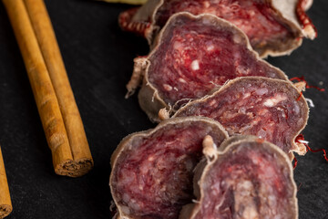 Unpeeled sliced pork salami with spices