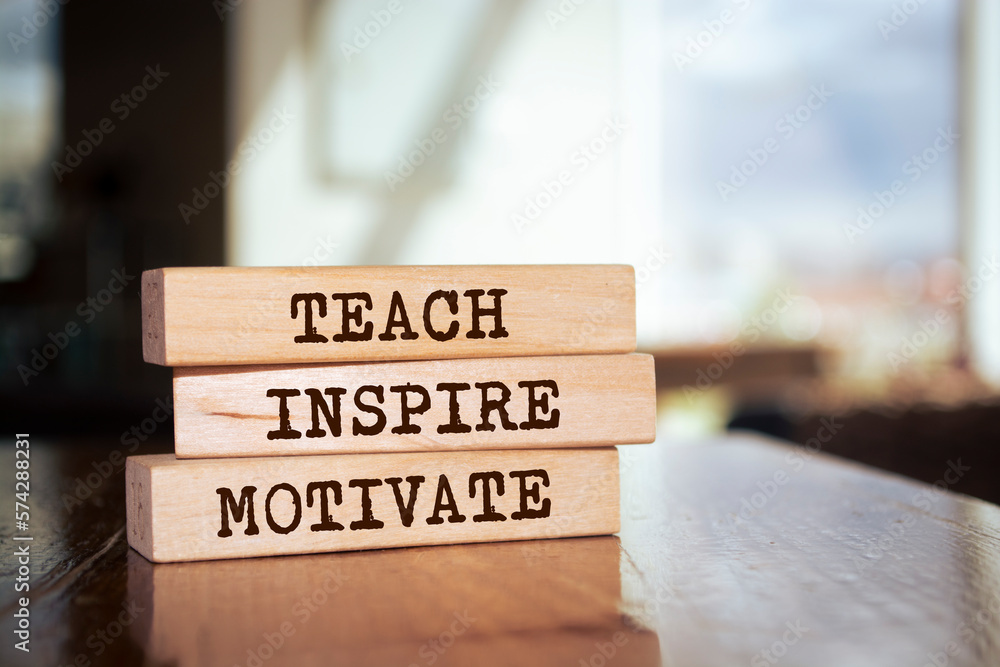 Wall mural wooden blocks with words 'teach inspire motivate'.