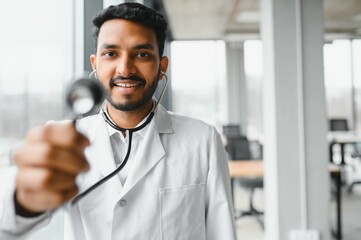 Fototapeta premium Handsome Indian Male Doctor holding empty white or blank dropper bottle