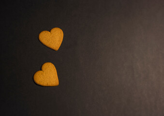 heart shaped cookies on black background, copy space 