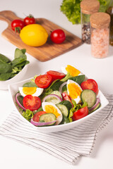 Appetizer healthy salad of fresh tomatoes, cucumber, spinach, lettuce and red onion. Vegan salad. Diet menu.