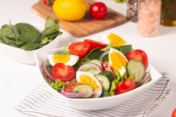 Appetizer healthy salad of fresh tomatoes, cucumber, spinach, lettuce and red onion. Vegan salad. Diet menu.