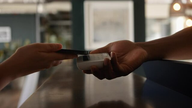 Anonymous Customer Paying with Smart phone on a digital Payment Terminal In a Store Close Up 
