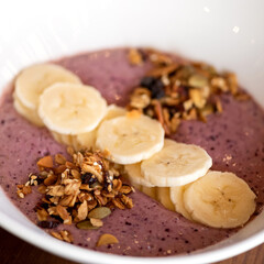 Fruit and berry smoothie with nuts and banana. Breakfast in plate. Healthy diet. Fitness menu. Healthy lifestyle. Vegetarian menu. Top view. Soft focus. Close-up. High quality photo