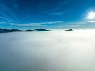 Fototapeta na wymiar Aerial view, flight above the clouds, the coast of Mallorca in the fog with the town of Santa Ponca, Mallorca, Spain